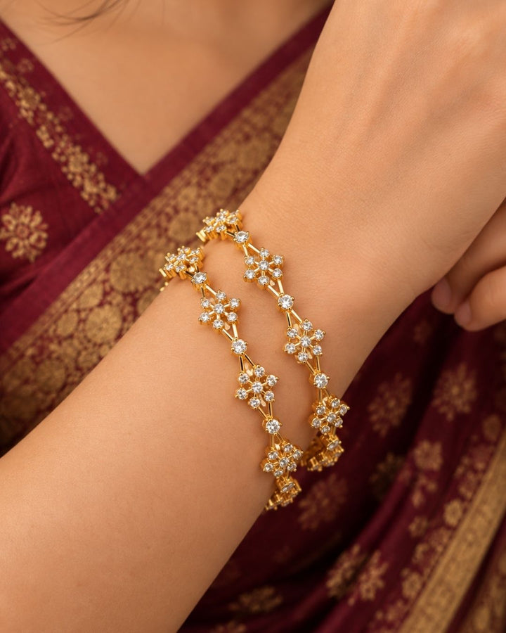 Premium floral gold plated bangles showcasing brilliant zircon detailing and an elegant handcrafted finish.
Lightweight, comfortable, and designed for all-day wear with traditional and modern outfits.
An ideal choice for weddings, festivals, gifting, and special occasions.