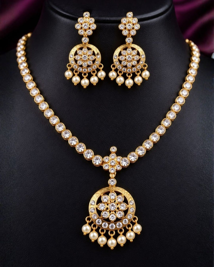 South indian Woman wearing a Gold plated zircon diamond necklace set featuring a sparkling floral pendant with pearl drops and matching earrings. Beautifully crafted with premium zircon stones, making it ideal for weddings, festive celebrations, receptions, and traditional occasions.