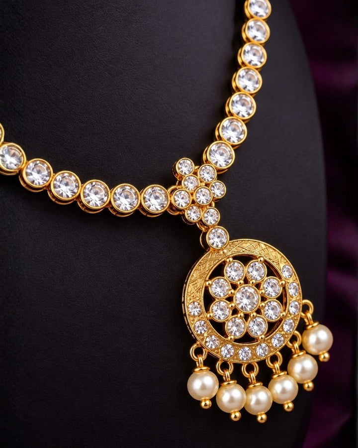 South indian Woman wearing a Gold plated zircon diamond necklace set featuring a sparkling floral pendant with pearl drops and matching earrings. Beautifully crafted with premium zircon stones, making it ideal for weddings, festive celebrations, receptions, and traditional occasions.