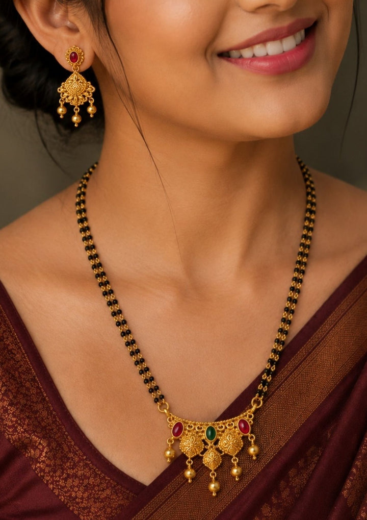 Beautiful 18K gold plated mangalsutra set featuring traditional double black bead chains, decorative pendant, and matching earrings. Lightweight, elegant, and perfect for daily wear, weddings, and traditional occasions.