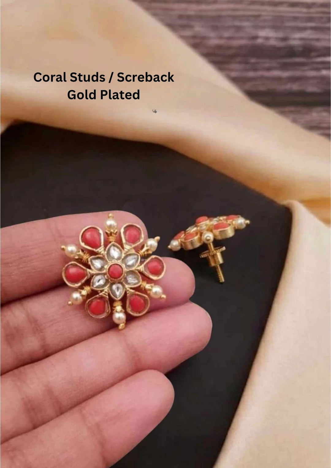 Traditional coral jhumkas gold plated screwback earrings The earrings are adorned with vibrant coral red bead danglers and detailed antique gold finish patterns, creating a rich South Indian ethnic look suitable for weddings, festivals, poojas and cultural celebrations
