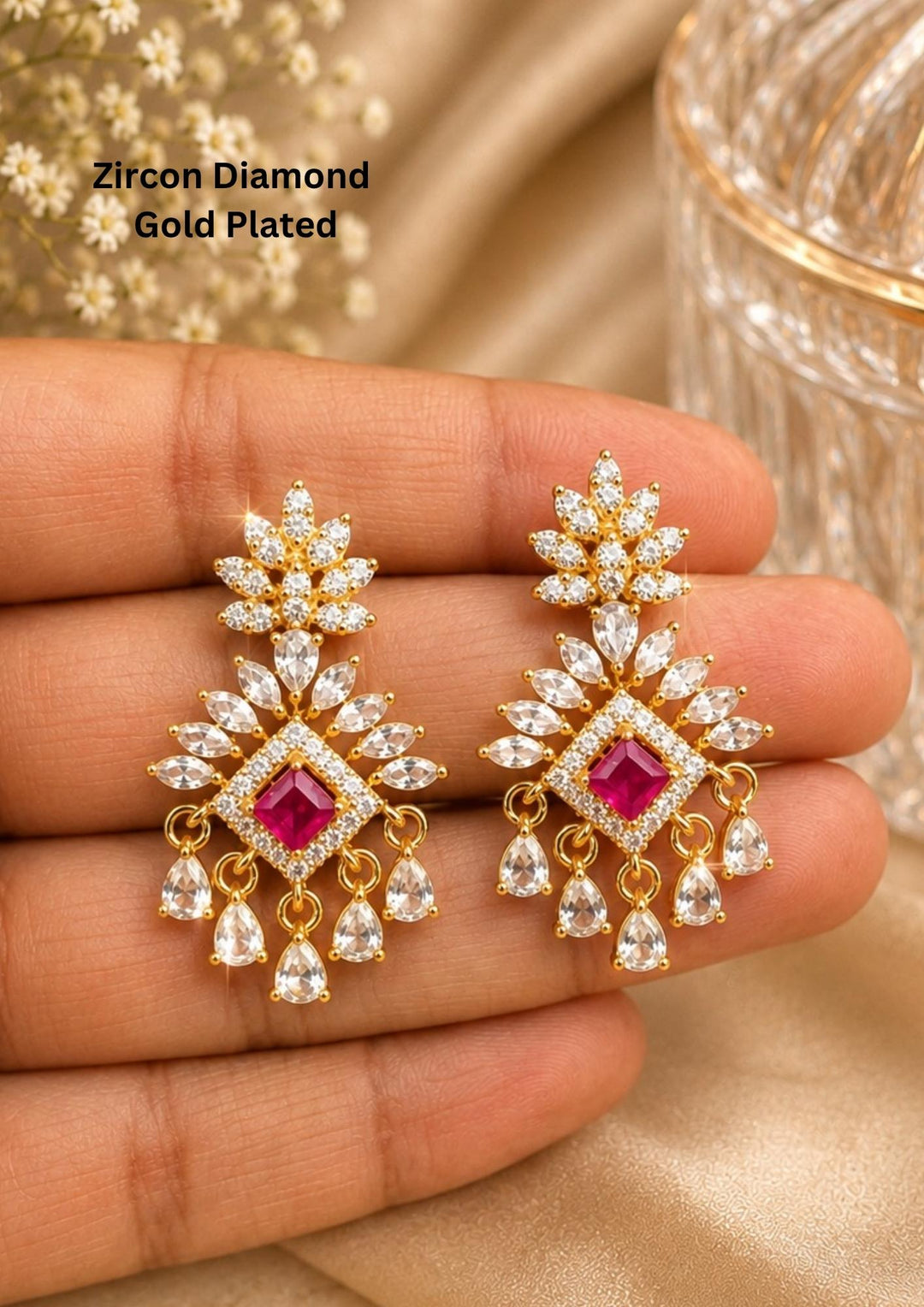 Gold-plated zircon diamond earrings with red gemstones held between zircon stones designed in flower shpae pattern with daimond peal drop hangings perfect for weddings, festivals