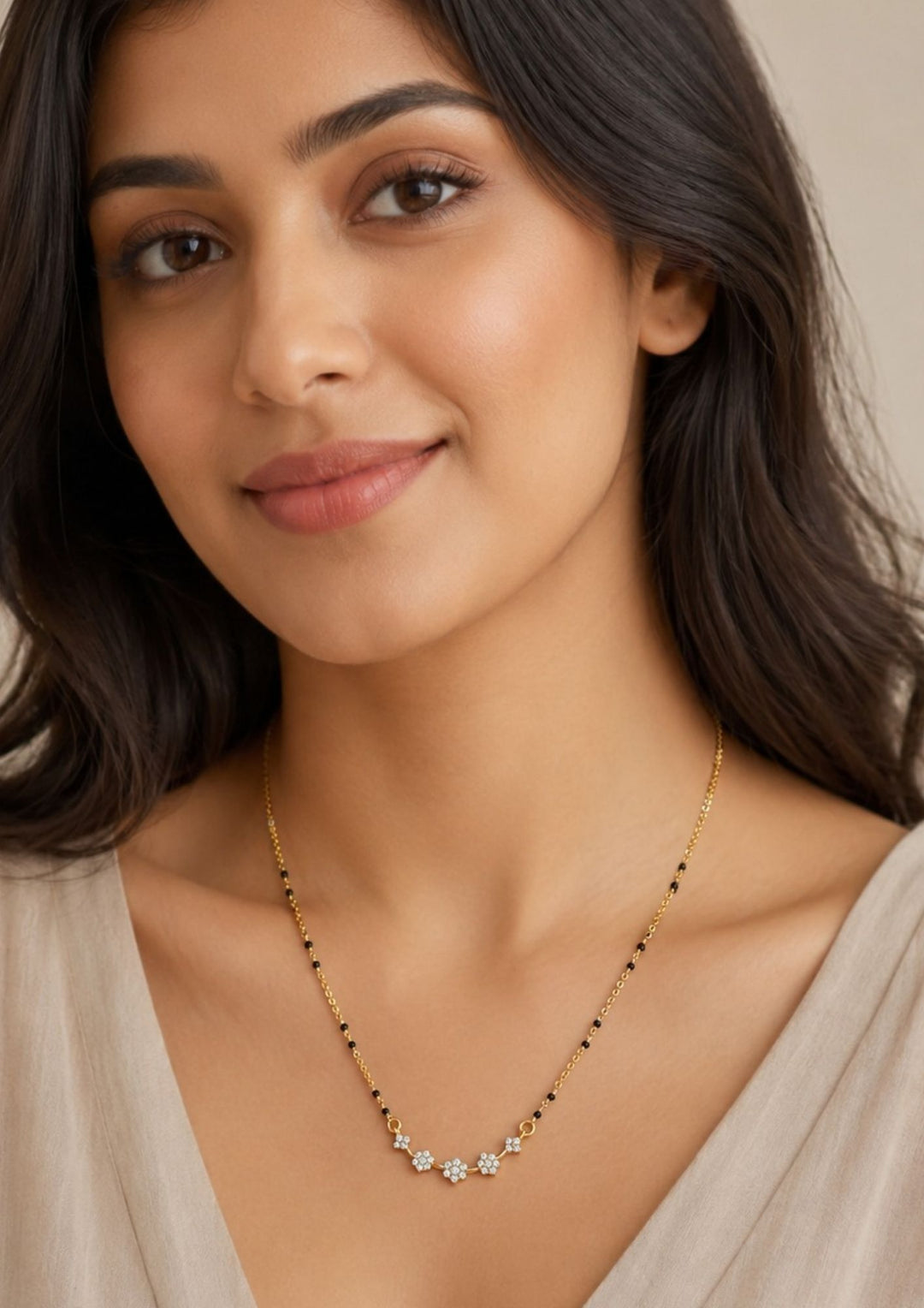 Woman wearing Gold plated black beads mangalsutra featuring delicate floral zircon motifs beautifully arranged along the centerpiece. Designed with a lightweight mangalsutra chain, perfect for everyday elegance and festive styling.