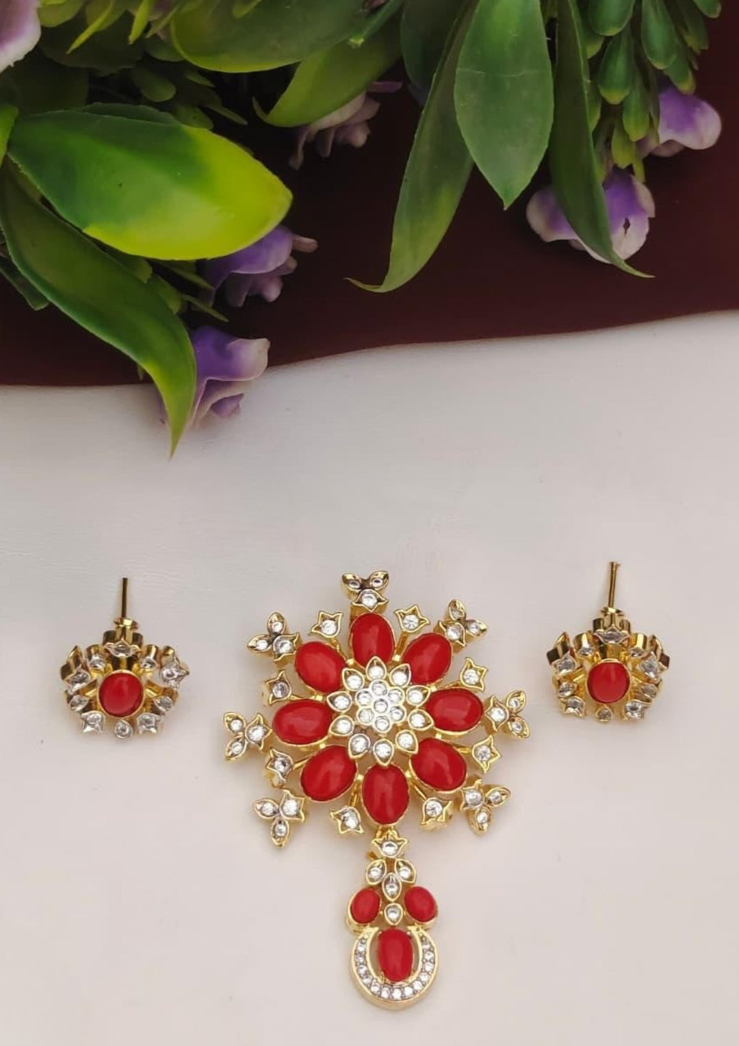 Gold and red jewelry set with earrings on a white background