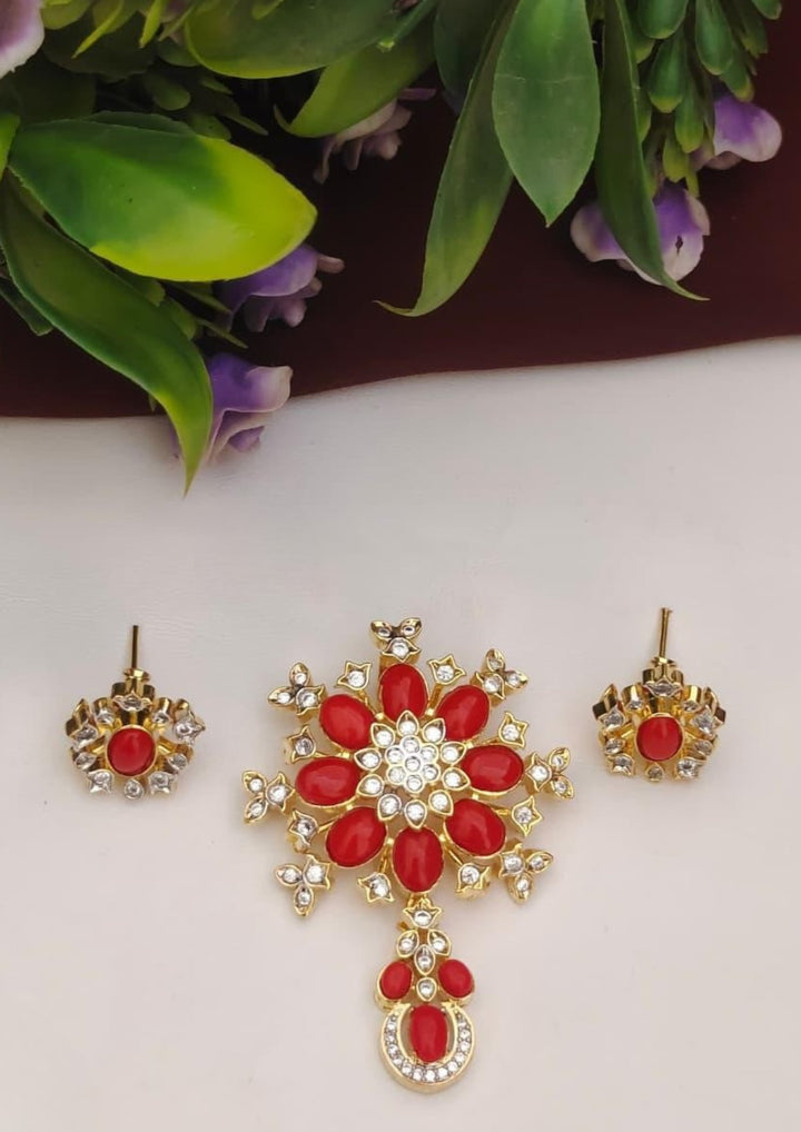 Gold and red jewelry set with earrings on a white background