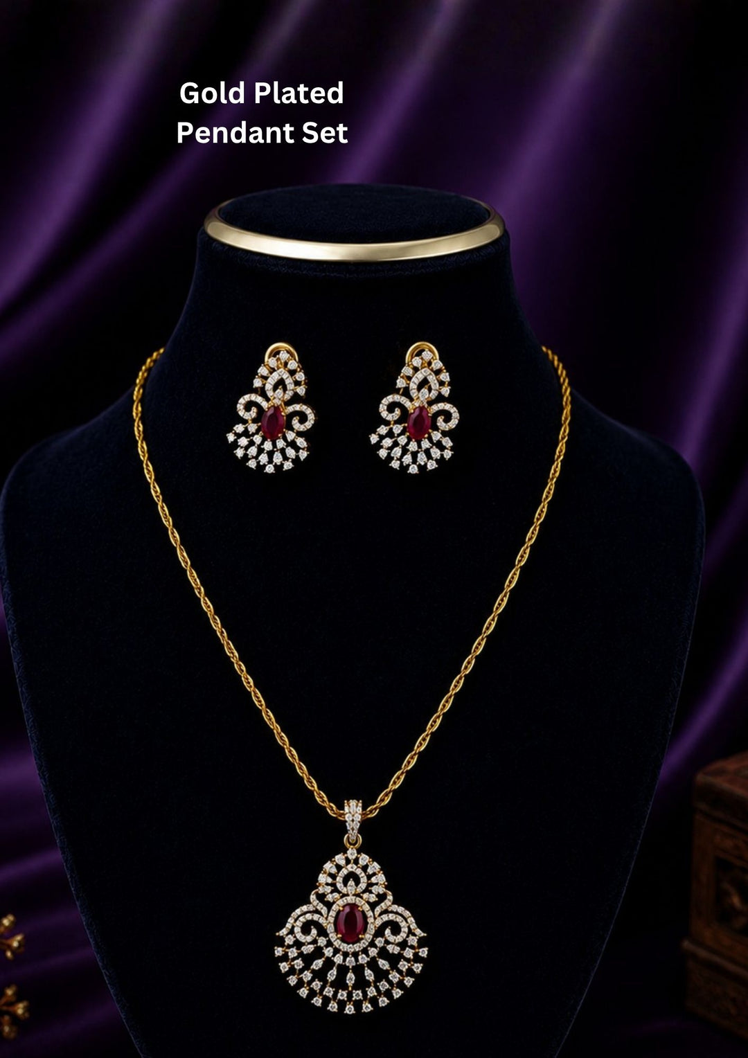 Zircon diamond gold plated pendant and earring set featuring a large open teardrop style chandelier pendant filled with tiers of shimmering white zircons and an oval-cut central ruby red gemstone. This lightweight matching set comes with smaller identical teardrop ruby earrings, providing an exceptionally brilliant diamond-look appearance suitable for weddings, receptions, festivals, cocktail parties, sarees, gowns, and ethnic fusion wear with skin-friendly quality, anti-fade premium polish, comfortable 