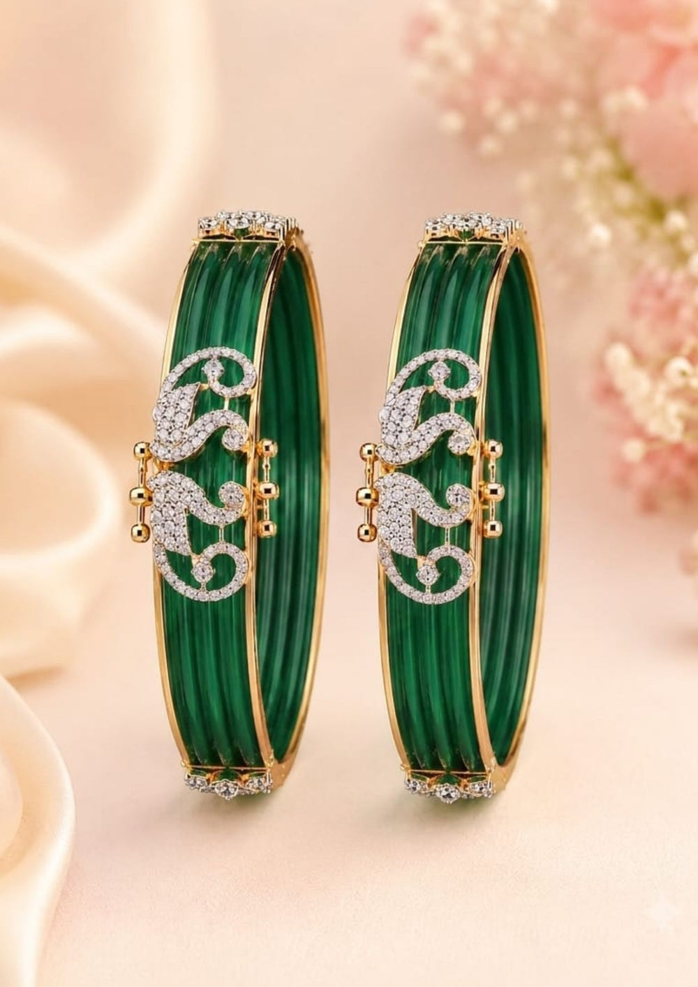A close-up of a person's wrist wearing A pair of traditional Indian bangles with vibrant magenta pink ribbed enamel, gold-plated borders, and intricate silver paisley motifs embellished with clear stones. Perfect for weddings, festive occasions, traditional wear, parties, and everyday styling. 