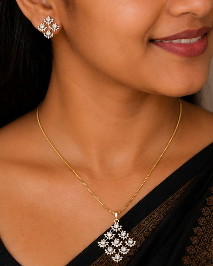 Gold plated chain set featuring a delicate floral-inspired square pendant with sparkling clear stones and matching floral stud earrings.