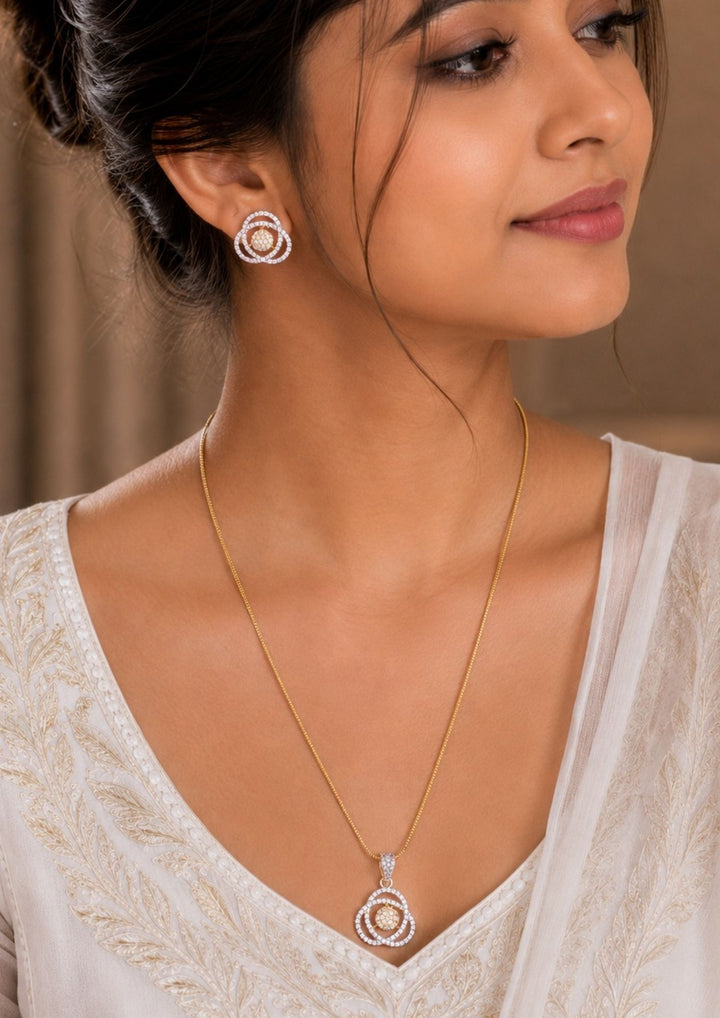 South Indian Woman wearing a Zircon diamond gold plated pendant set design with sparkling white zircon stones in an elegant layered rose flower pattern with premium gold plated finish and sleek lightweight chain design. The pendant and earrings showcase a modern rose inspired circular floral model with micro zircon detailing at the center, giving a rich diamond look suitable for daily wear, office wear, parties, casual outings, festivals.