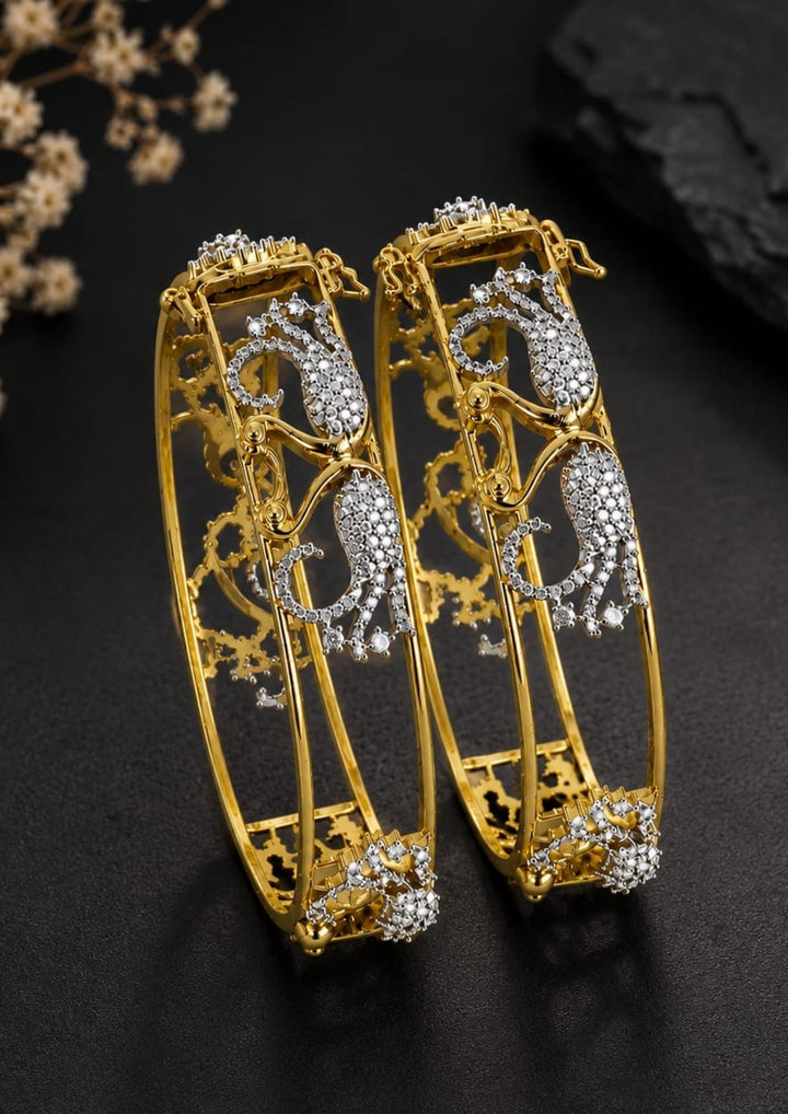 A pair of traditional Indian bangles with vibrant magenta pink ribbed enamel, gold-plated borders, and intricate silver paisley motifs embellished with clear stones. Perfect for weddings, festive occasions, traditional wear, parties, and everyday styling. 