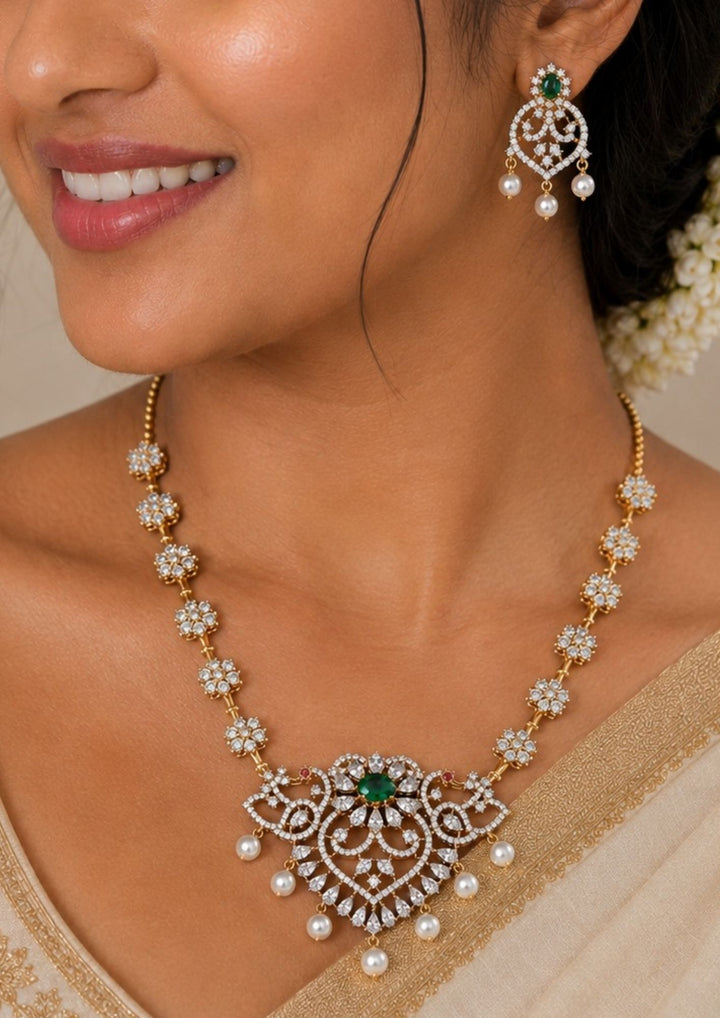 Woman wearing a Gold-plated zircon diamond necklace and earrings comes with peacock design and shows in detailed how it look and looks and comes with green gemstone and very classy and neat finishing and can be use for festival , weeding and can gift 