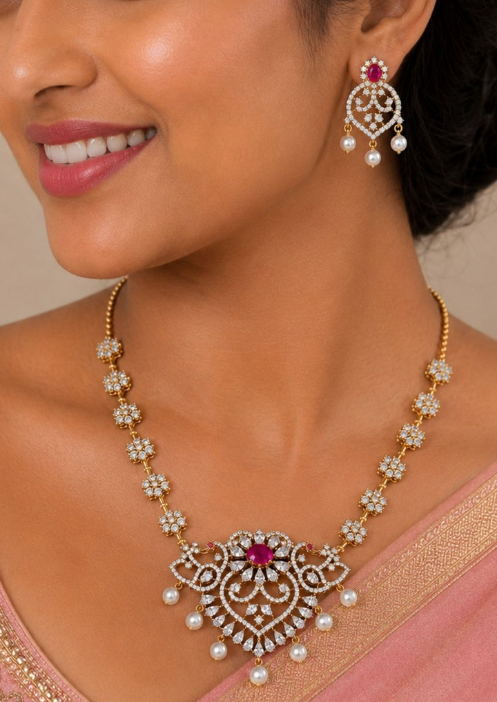 Woman wearing a Gold-plated zircon diamond necklace and earrings comes with peacock design and shows in detailed how it look and looks and comes with pink gemstone and very classy and neat finishing and can be use for festival , weeding and can gift 