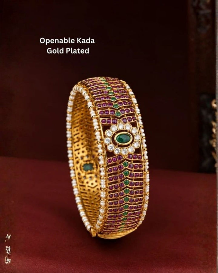 Premium Openable Gold Plated Kada showcasing an elegant oval green centerpiece, ruby stone work, crystal halo, pearl edges, and a hinged openable design.