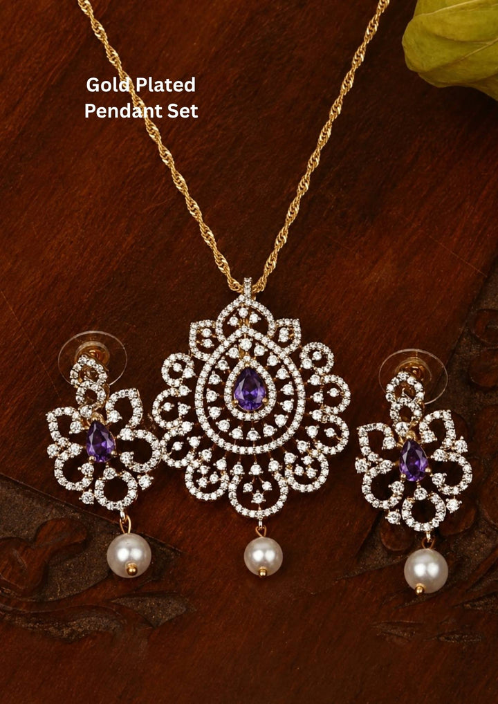 Elegant zircon diamond gold plated pendant set featuring a floral-inspired pendant designed with sparkling white zircon stones arranged in circular patterns. The centerpiece showcases a pear-shaped emerald red stone surrounded by dazzling zircon stones, finished with a delicate pearl drop. The matching earrings mirror the same floral design with green stone and pearl danglers, Perfect for weddings, festivals, office wear, functions and its anti fade color