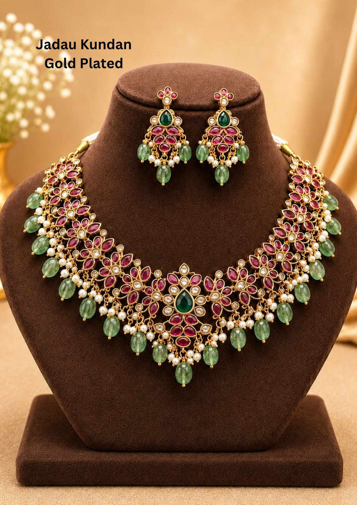 Traditional style 18K gold plated Jadau choker necklace set designed with a pink stone border band, sparkling kundan outlines, a central crescent pendant, and rows of hanging white pearl drops that give a graceful traditional look for festive celebrations, poojas, family functions, and bridal outfits.