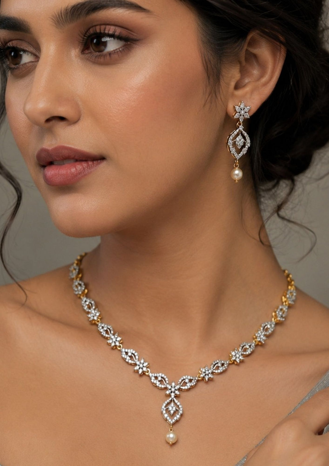 South Indian Woman wearing An elegant zircon diamond gold plated necklace set features a delicate V-shaped chain adorned with sparkling floral marquise stones and a central hanging pearl drop, complemented by matching floral teardrop earrings with pearl accents.