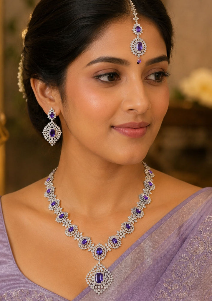 South Indian wearing Beautiful zircon diamond gold plated purple necklace set featuring sparkling violet stones and matching long earrings. Perfect for weddings, receptions, parties, festive occasions, and premium gifting.