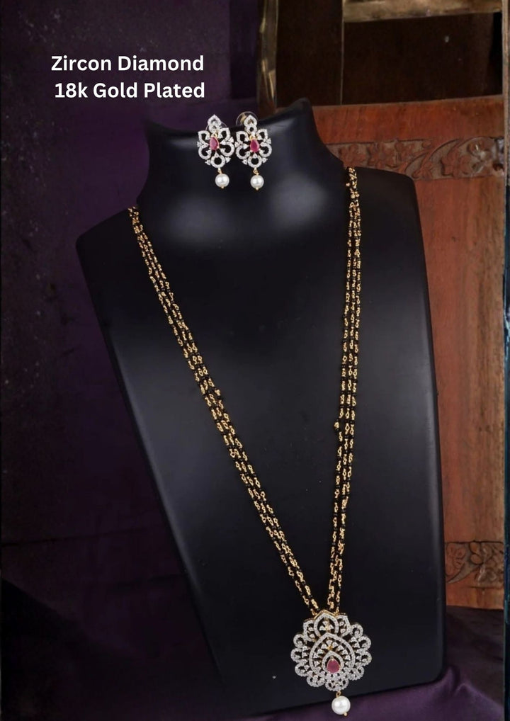 Elegant diamond replica black beads mangalsutra chain featuring a slim gold plated chain with evenly spaced traditional black beads and a curved center pendant decorated with tiny dangling zircon purple stone pendant. The lightweight 24 inch necklace gives a modern minimal look suitable for daily wear, office wear, married women, festive occasions and traditional outfits.