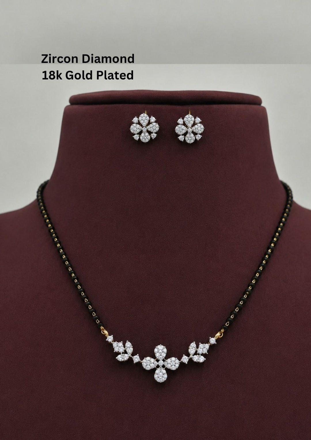 Gold plated black beads mangalsutra featuring an elegant flower pendent and Studs -inspired zircon centerpiece with delicate curved detailing. Lightweight and beautifully crafted for everyday elegance, festive occasions, and gifting.
