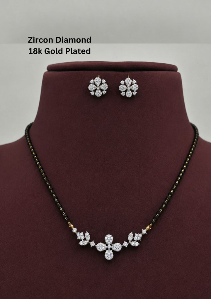 Gold plated black beads mangalsutra featuring an elegant flower pendent and Studs -inspired zircon centerpiece with delicate curved detailing. Lightweight and beautifully crafted for everyday elegance, festive occasions, and gifting.