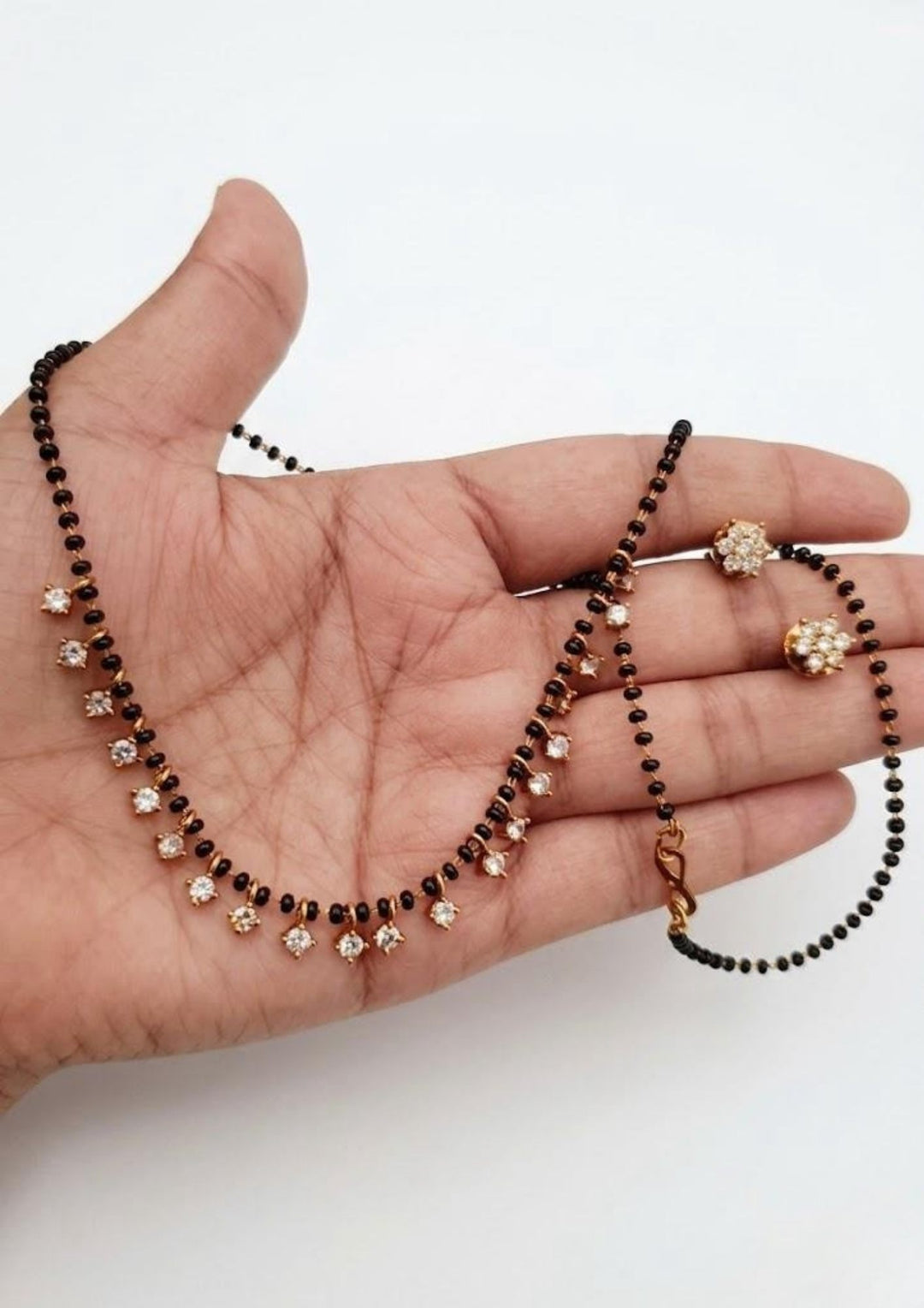 zircon diamond gold plated mangalsutra (nallapusallu) with studs and picture shows with background its is very simple and can use for dailyware and officeware and poojas and can gift for your loved ones 